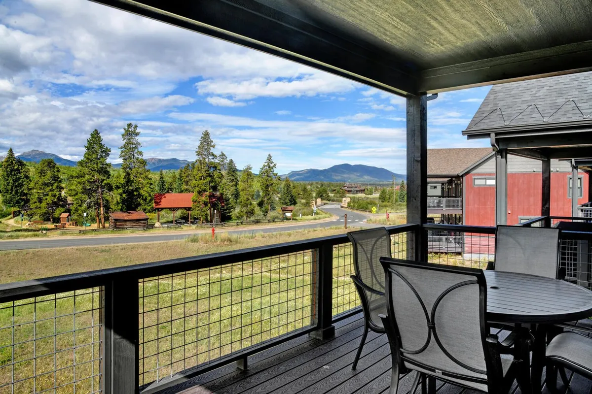 A tranquil outdoor seating area overlooks breathtaking mountain views, framed by surrounding trees. The space exudes calm and is ideal for sharing stories, enjoying meals together, or simply appreciating nature with loved ones.